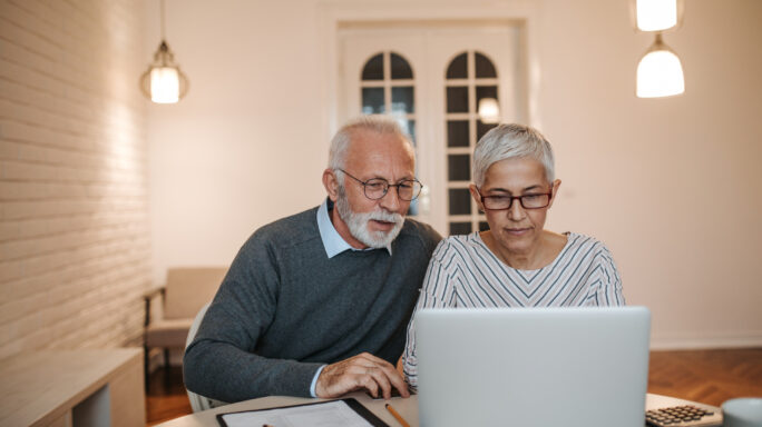 Zwei ältere Menschen vor dem Laptop