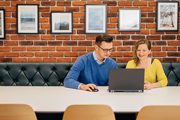 Man and woman working together over laptop