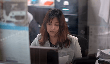 Worker at Sonora Foods, sat at computer