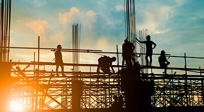Scaffolding at sunrise, people working