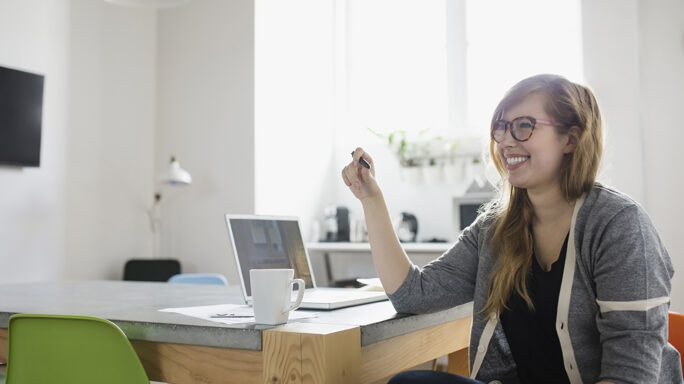 Smiling businesswoman at laptop in office