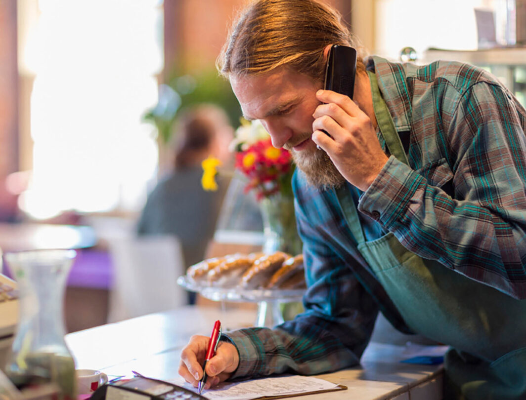 cafe owner takes a call from a customer