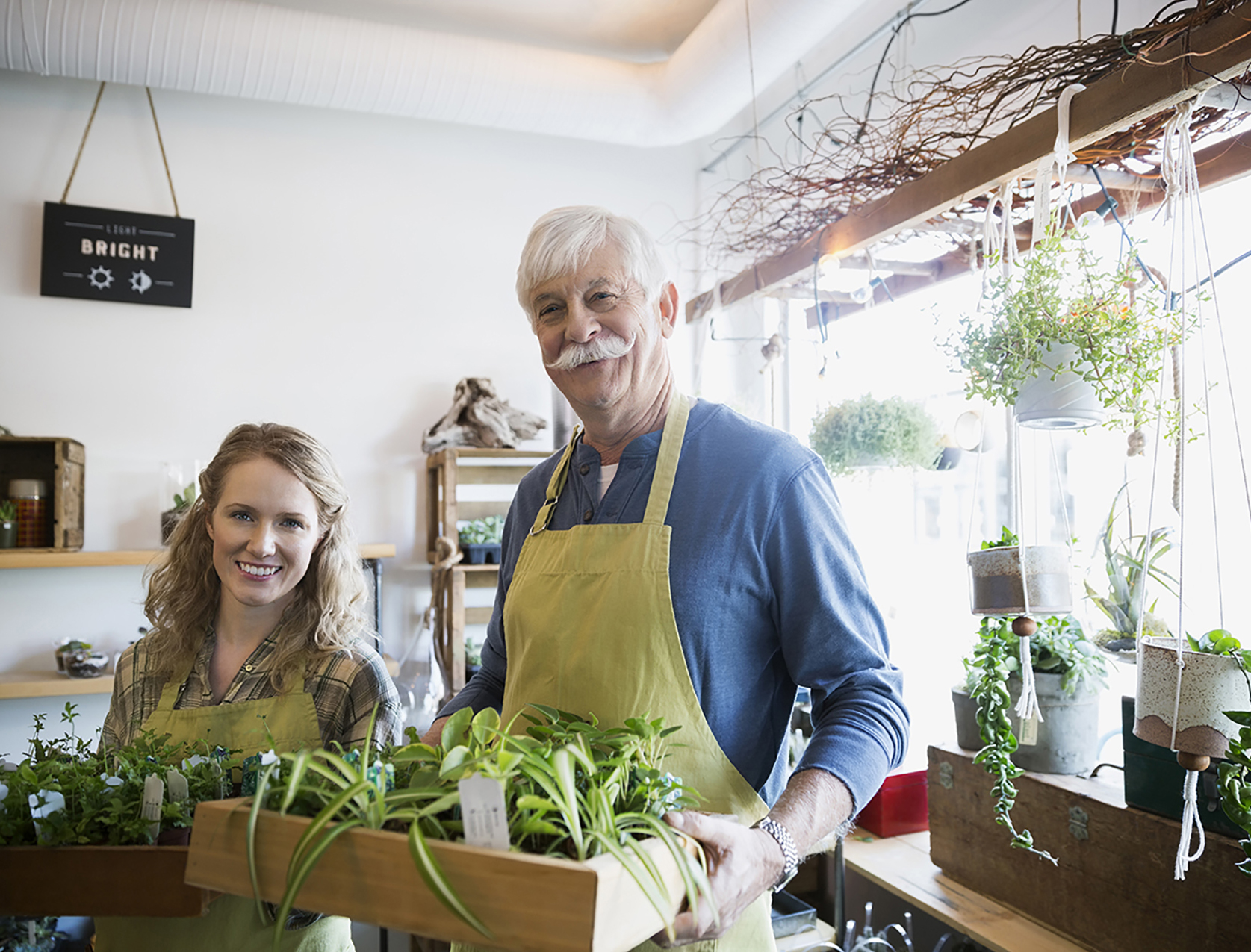 Portrait of confident terrarium shop owners holding plants