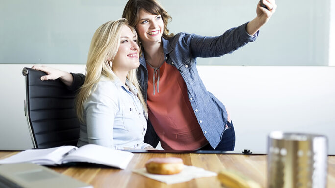 Two female office workers taking a selfie