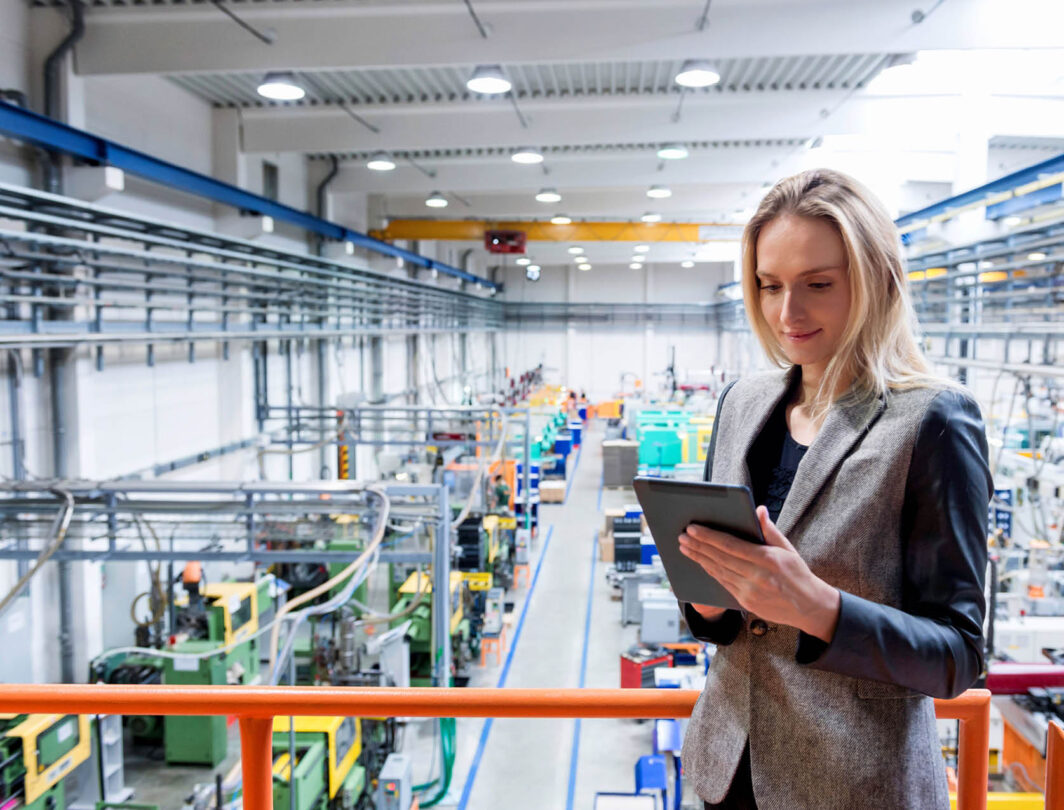 woman inspects data on an ipad in the factory floor