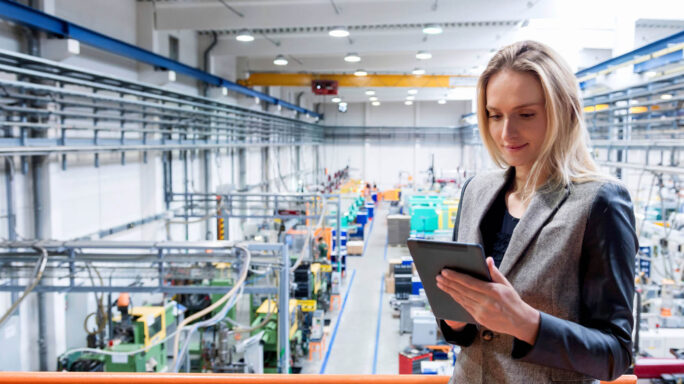 woman inspects data on an ipad in the factory floor