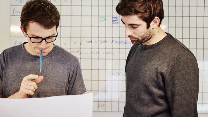 Two men looking at charts