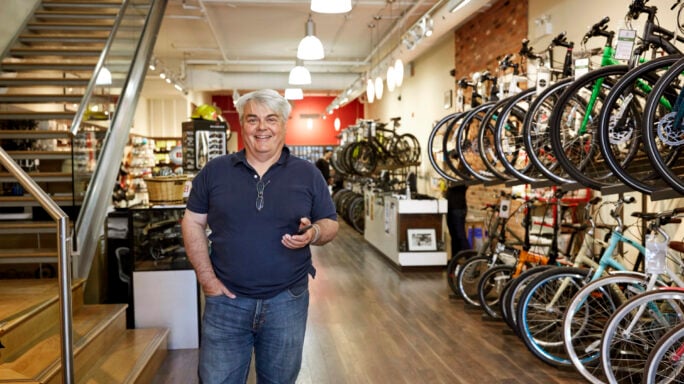 Man with grey hair standing in a bike shop