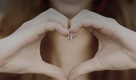 Woman holding her hands together to form a heart shape