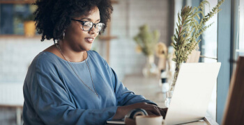 Sage Foundation Impact Report 2020 - cover image of woman sitting in front of laptop