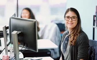 People analytics: 5 vital steps to greater workforce visibility ebook cover photo of woman smiling working at desktop