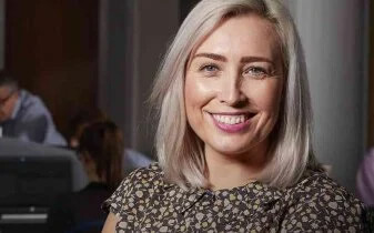 The changing face of HR research report - Financial services edition cover photo of a smiling woman