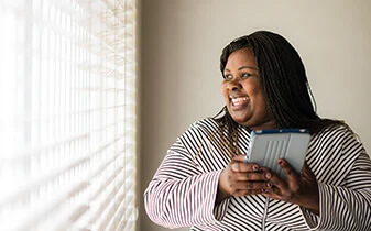 HR automation: Why the time is now report cover photo of woman smiling working on a tablet