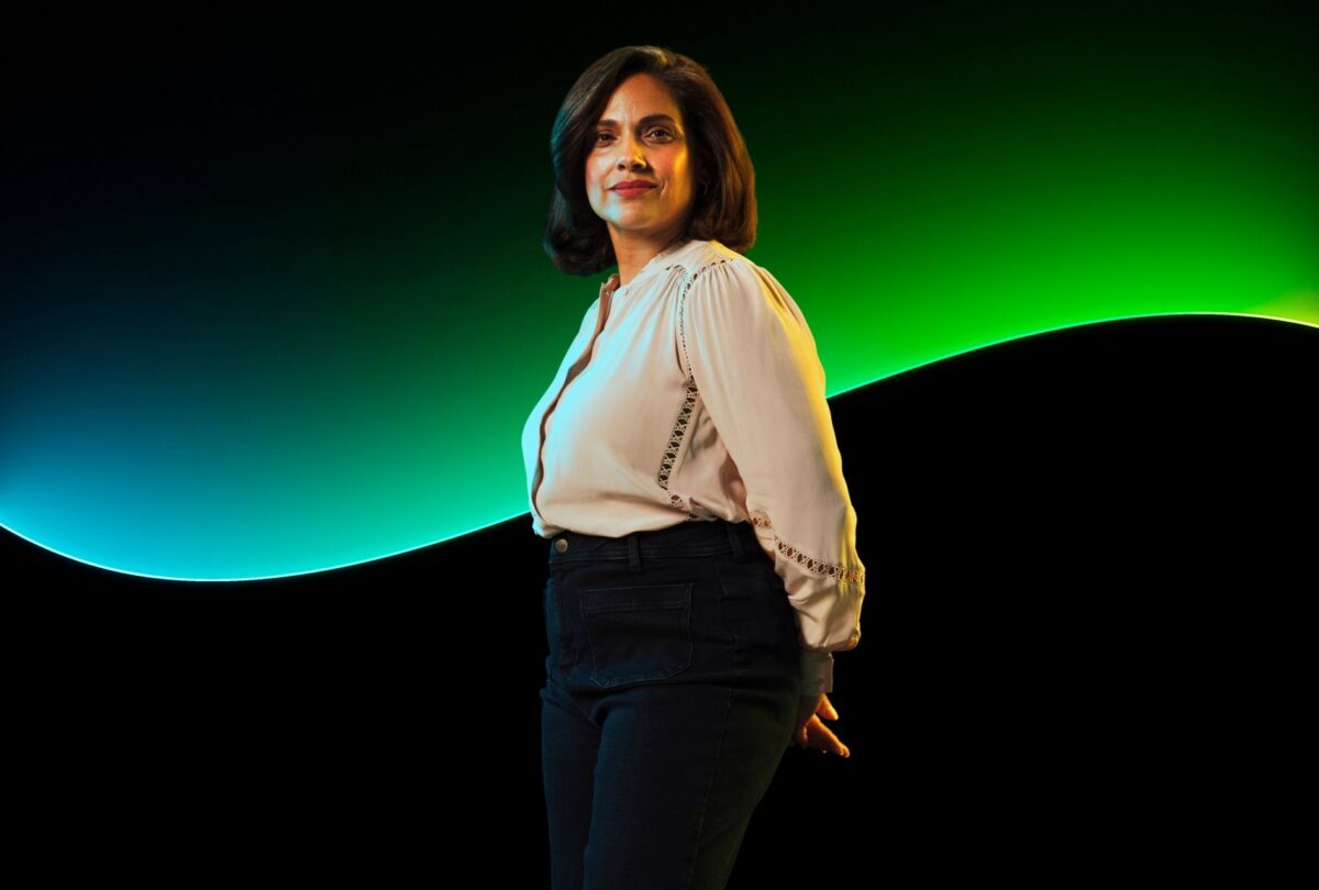 A woman looks to camera with the Sage glow line in the background.