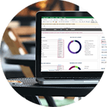 Roundel of a laptop displaying a budget planner on a round metal table in a coffee shop