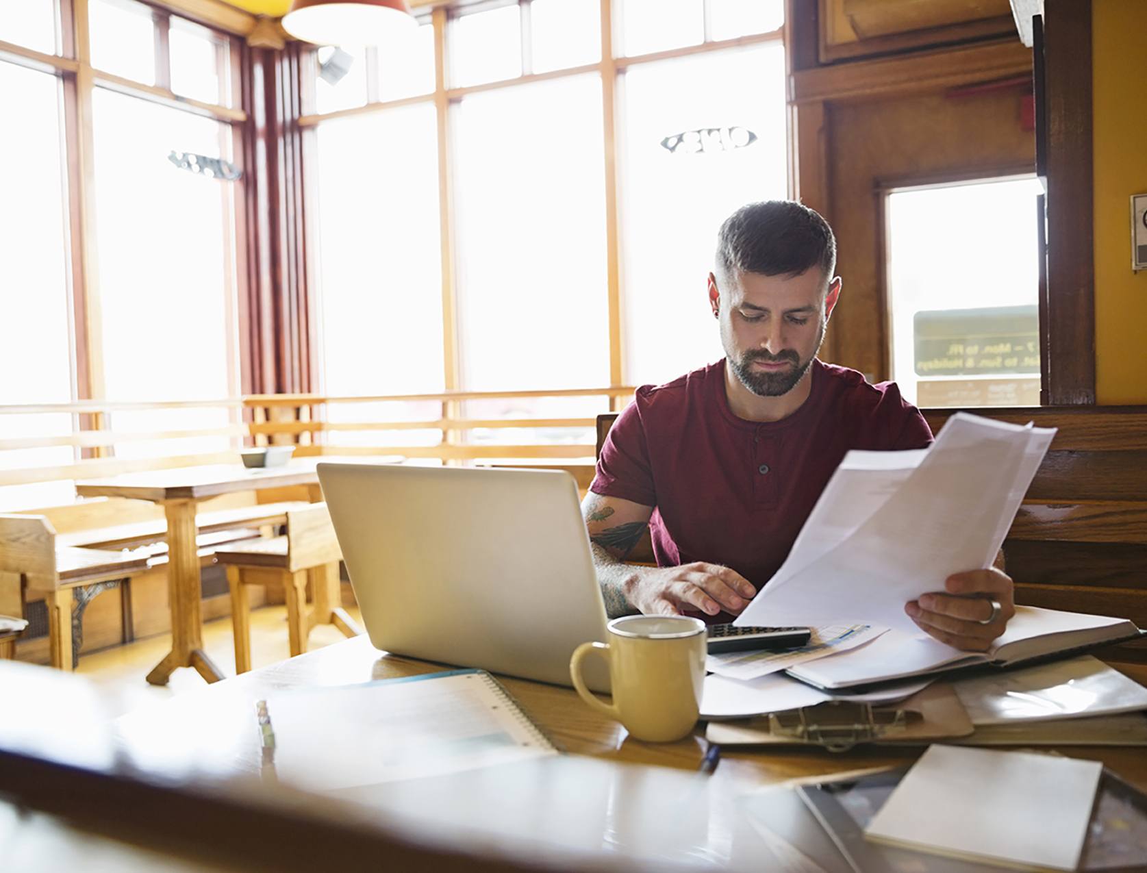 Man with papers in hand working from home