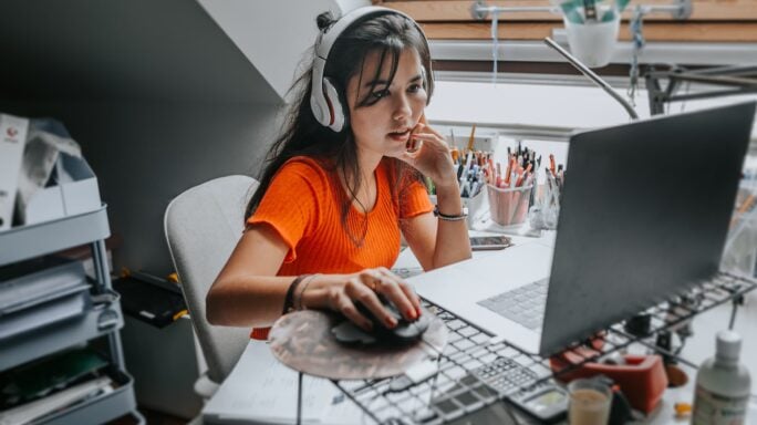 woman putting on headset working on computer