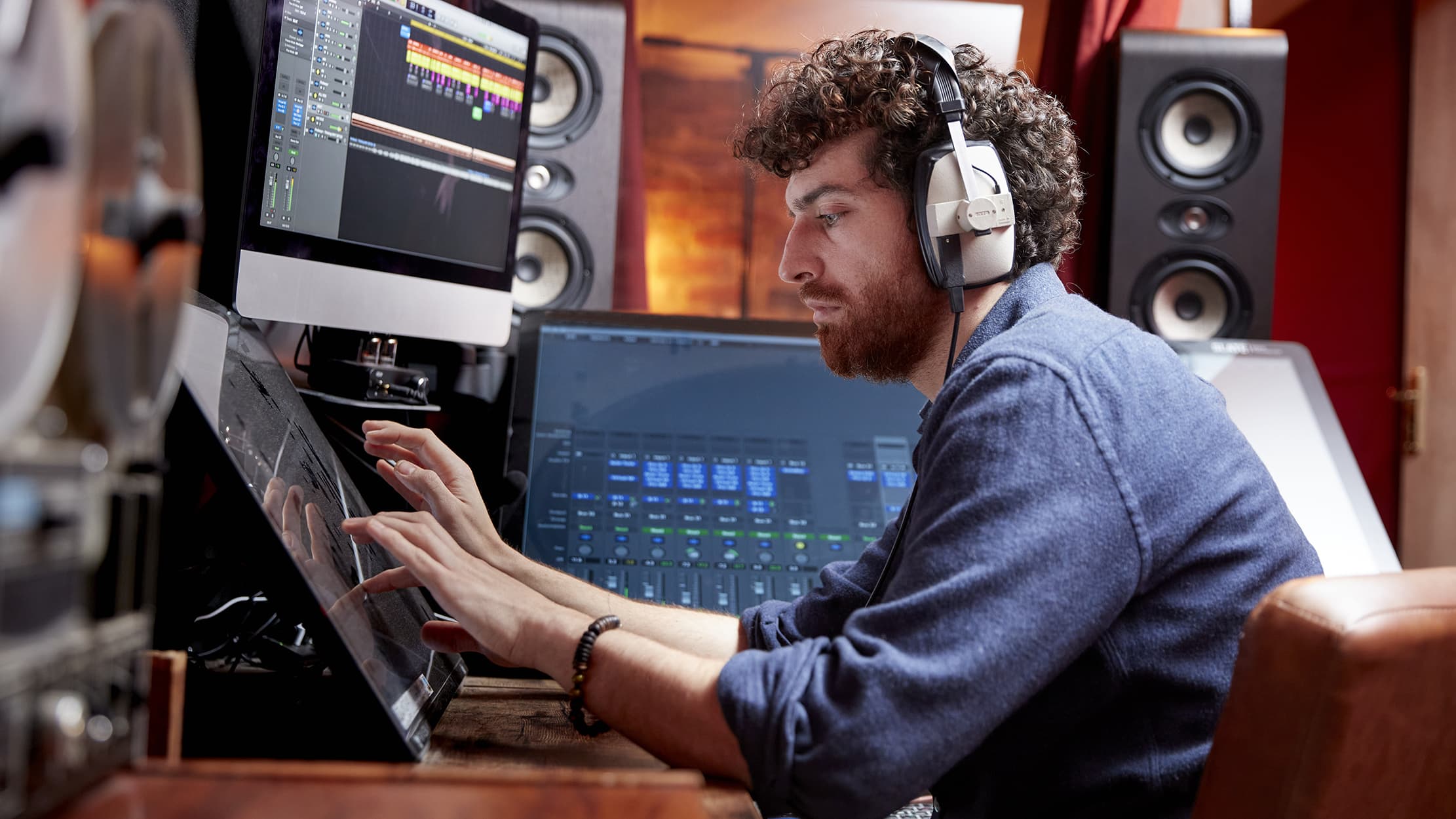 Sound producer wearing operating two computers