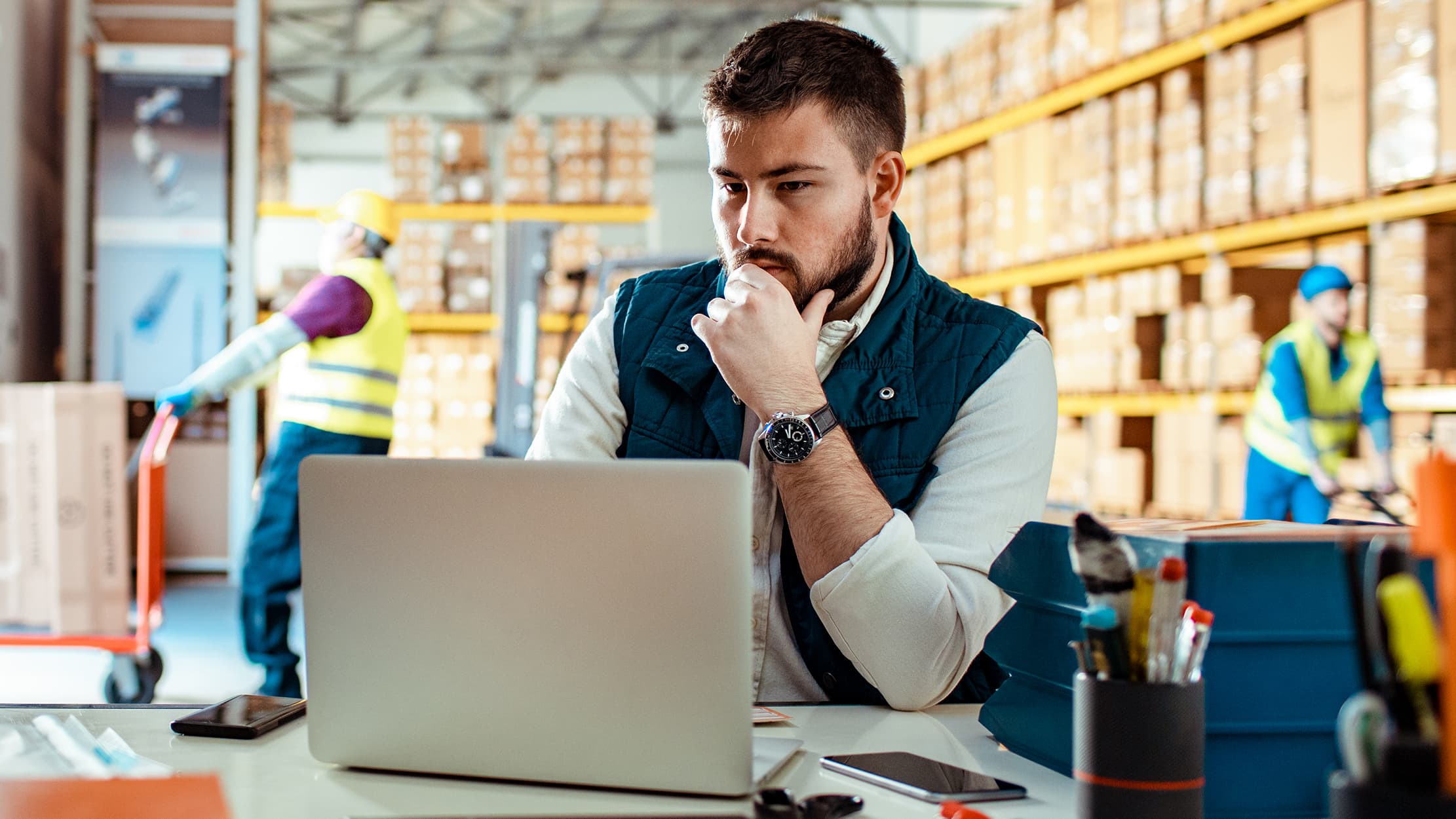 A man operating a computer in a factory space