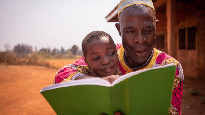 African man reading to boy