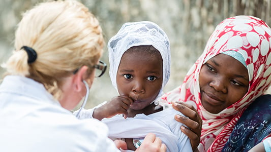 Volunteer doctor examining African child