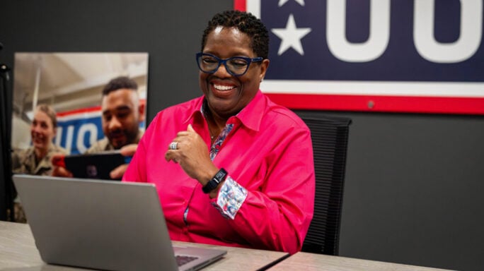 Photo of Michelle Turner smiling and sitting at a computer