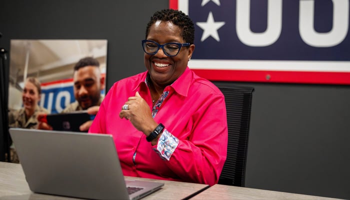 Photo of Michelle Turner smiling and sitting at a computer