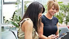two ladies working on laptop and tablet