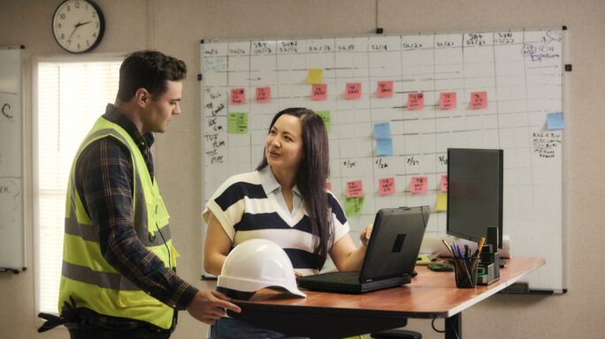 Chica revisando temas en el trabajo con un compañero