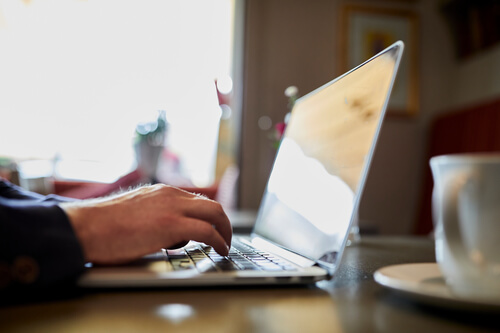 man and woman talking with a laptop between them
