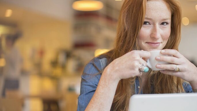 Une femme dans un café avec son ordinateur portable, en bonne conscience et conformément à RGPD
