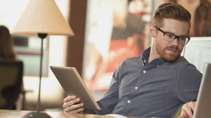 Un homme dans un bureau sans papier travaille sur son ordinateur portable.