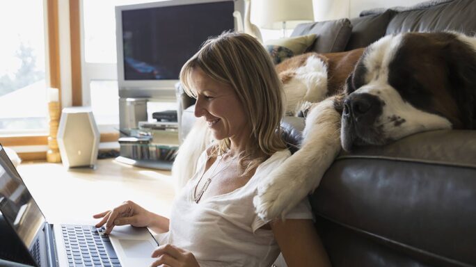 Une femme travaille à domicile sur son ordinateur portable, et utilise le cloud