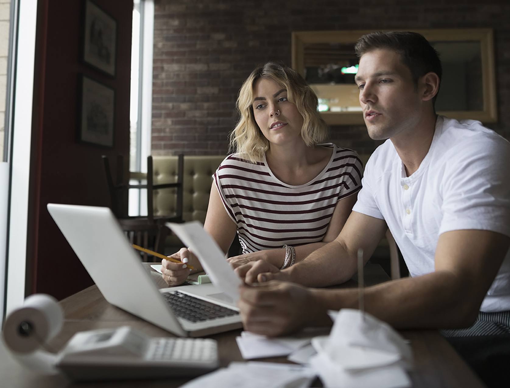 Un homme et une femme entrent leurs documents dans un logiciel de comptabilité