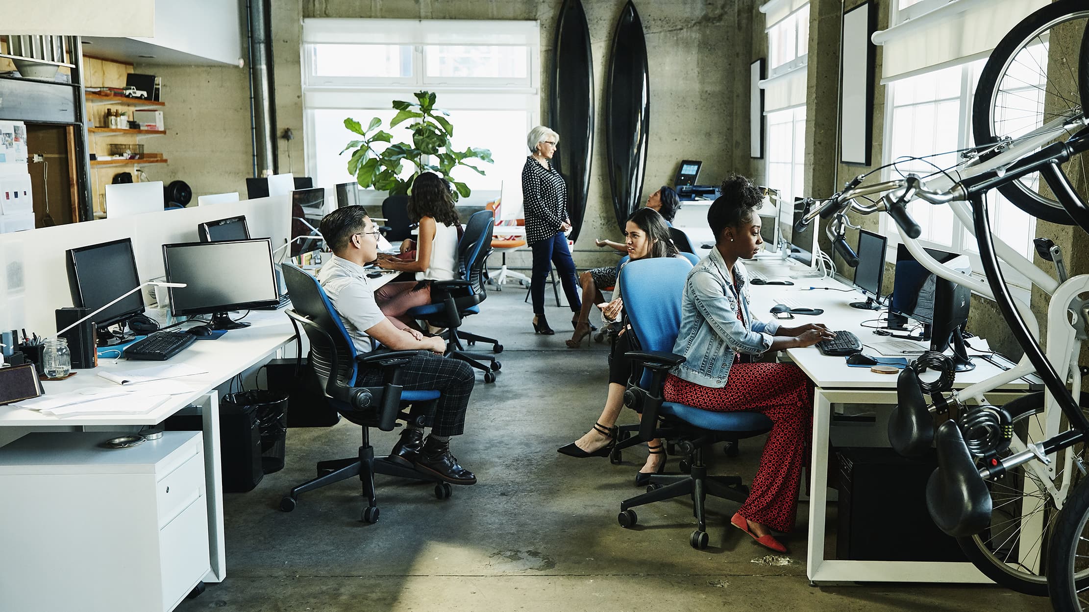 Des collègues travaillent dans un bureau moderne; l'amortissement des actifs immobilisés contient des bureaux, chaises, ordinateurs,...