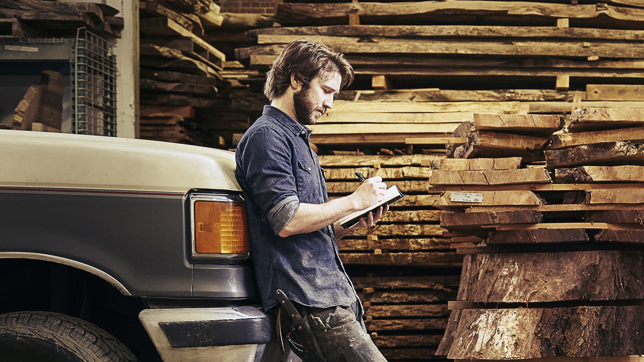 Un technicien indépendant se tient devant sa camionnette en pense sur la discipline financière.
