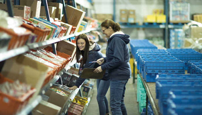 2 women shelving inventory