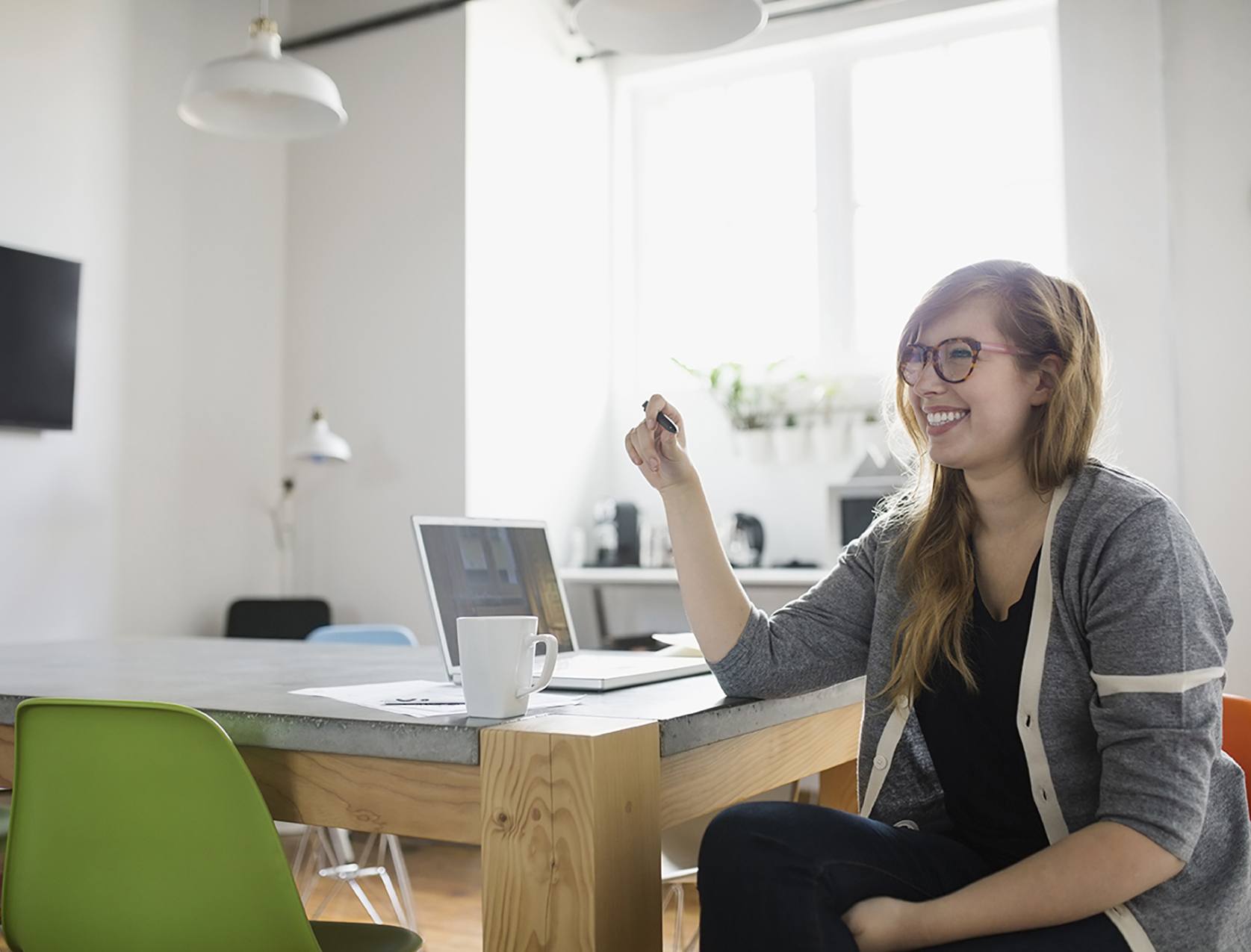 Une femme souriante avec un ordinateur dans un bureau