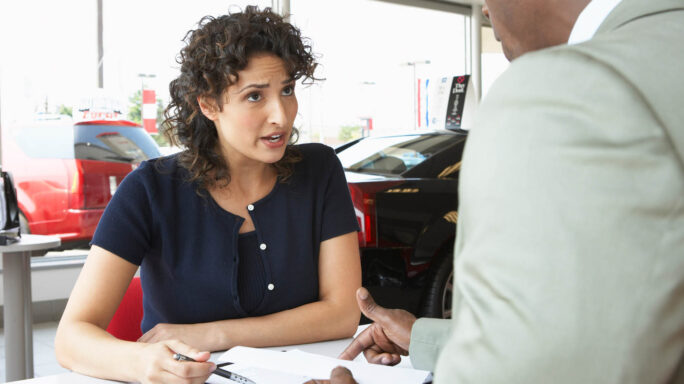 Un vendeur de voitures en parlant avec une cliente