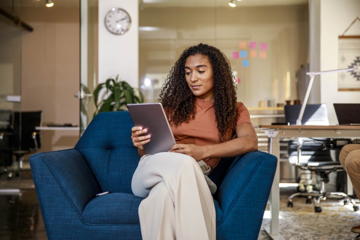 Une jeune femme au bureau travaille. sur une tablette