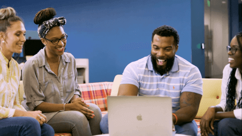 Diverse Sage colleagues smiling while sitting around in an office