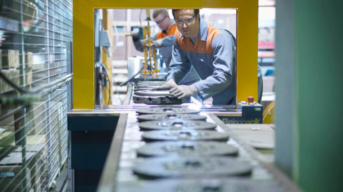 Twee mannen staan aan de productieband in een fabriek