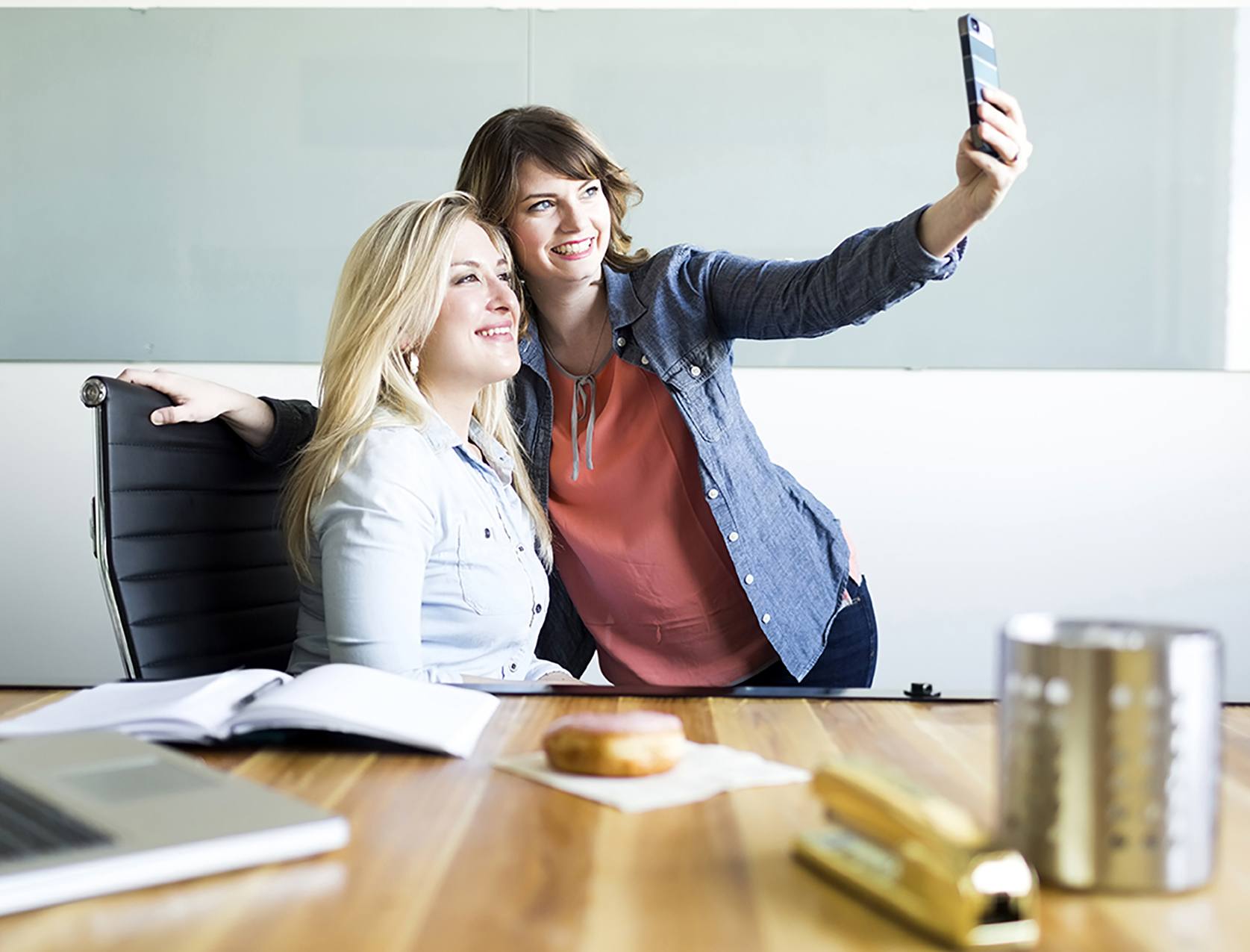 Twee vrouwelijke collega's maken samen een selfie en zijn trots dat ze in een People Company werken