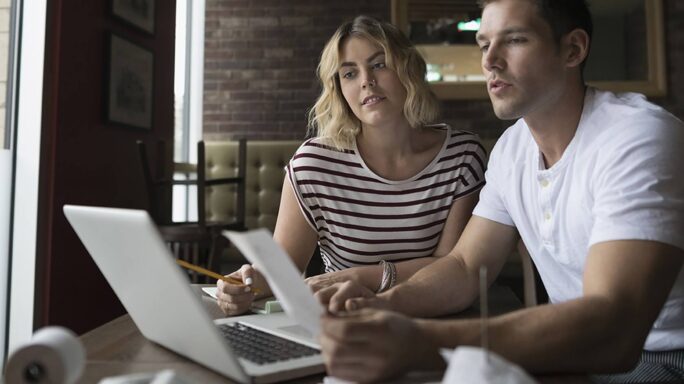 Een man en vrouw geven hun papieren in in een digitale boekhoudsoftware