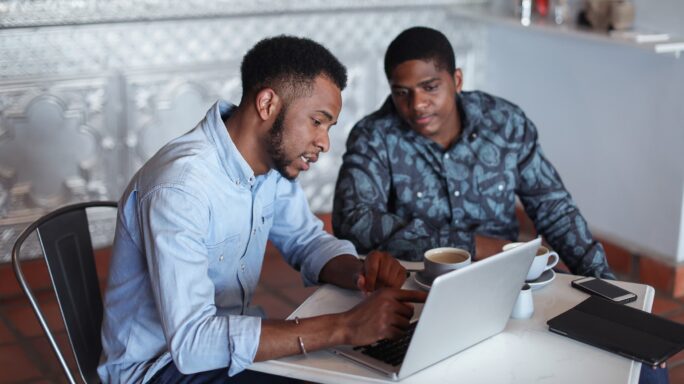 Twee mannen bekijken op een laptop wat de voordelen van een BI oplossing zijn.