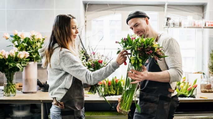 Een man is aan het werk in zijn eigen bloemenzaak. Qua soort ondernemer is hij een Fervente Werker.