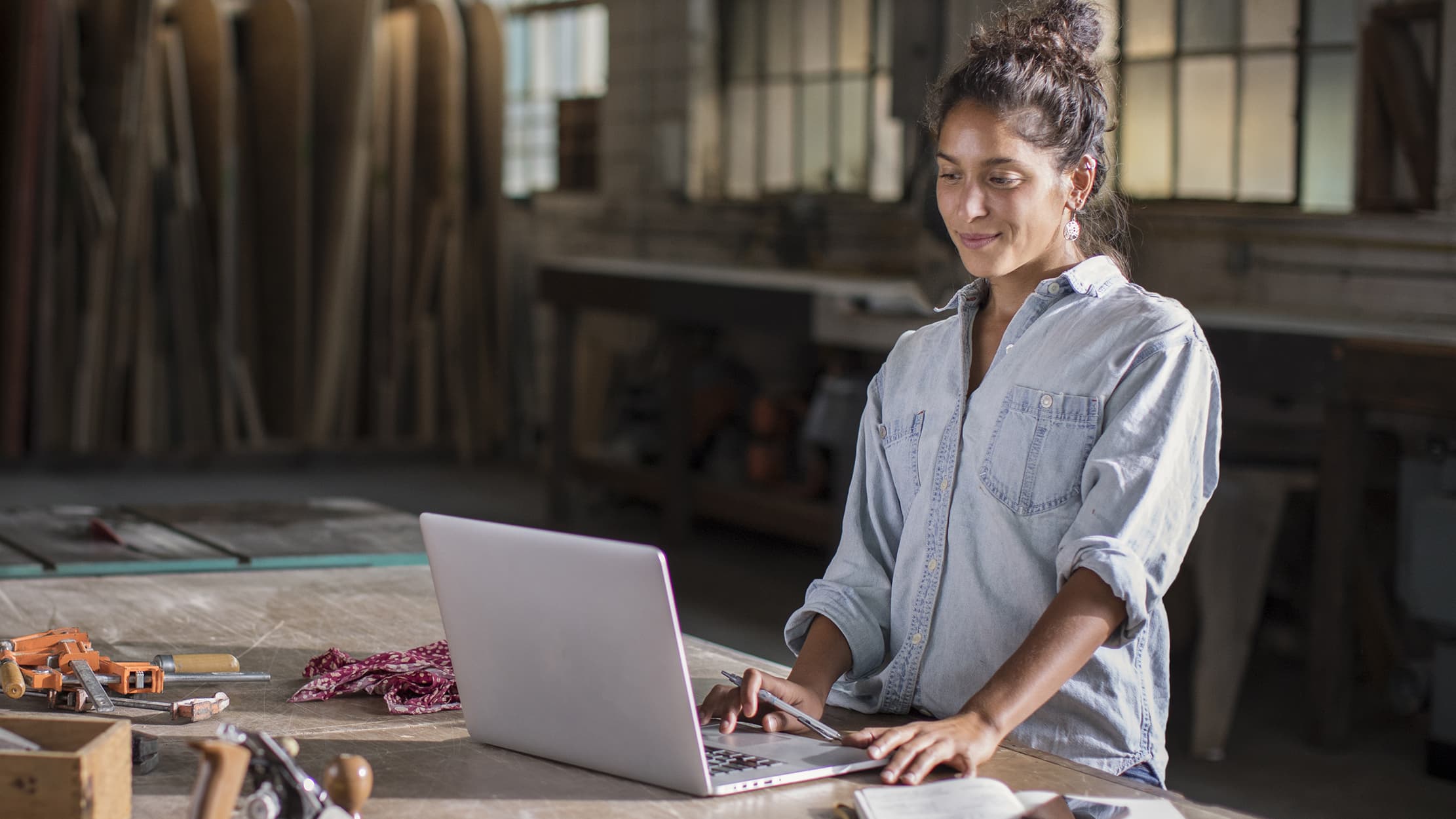 Een zakenvrouw in een werkruimte kijkt op een laptop
