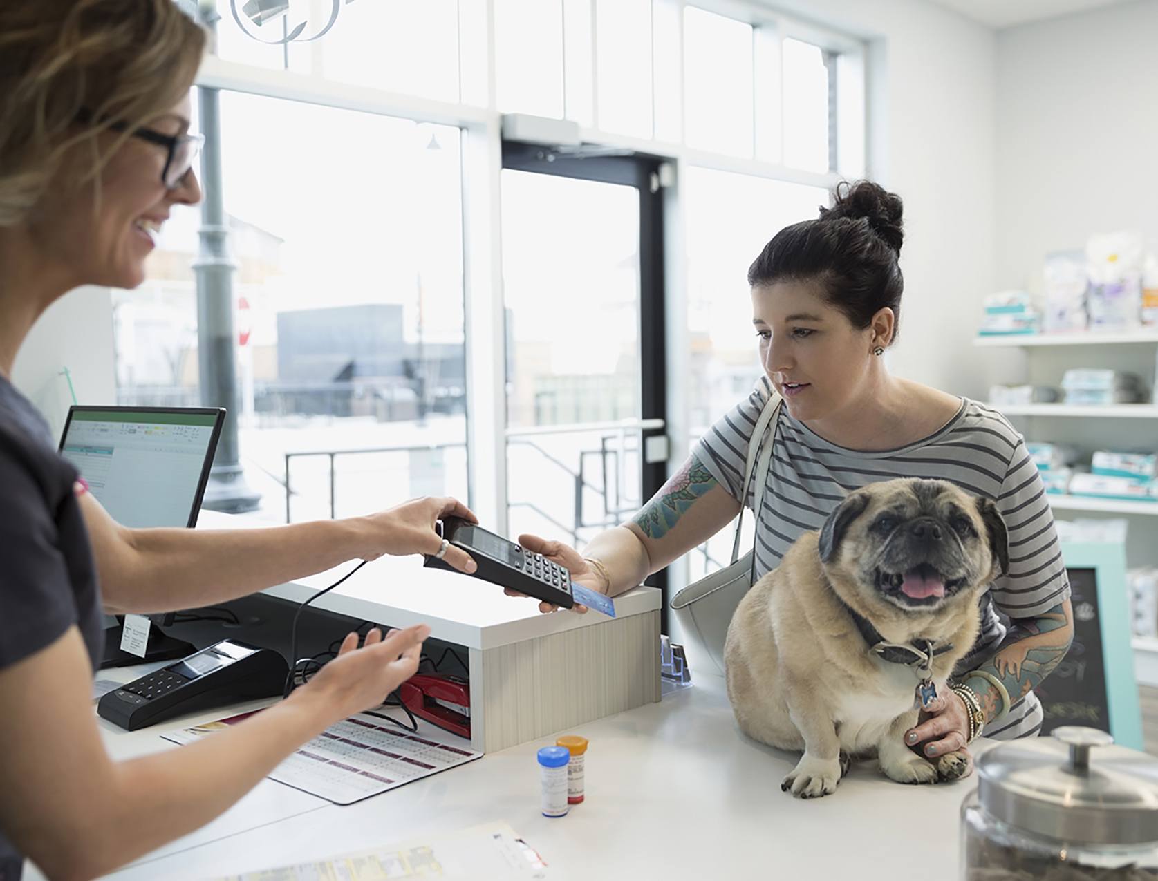 Mulher com cão a fazer um pagamento eletrónico