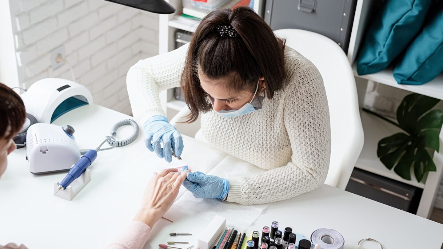 Jovem empreendedora a trabalhar concentradamente no seu escritório moderno, rodeada por materiais de trabalho, portátil e apontamentos, simbolizando inovação e dedicação ao seu próprio negócio.